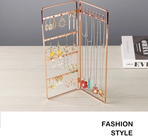 Detail of rose gold iron earring organizer with necklace hooks on a wooden desk