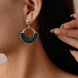 Detailed close-up of dark green leather wrapped geometric hoop earring on model