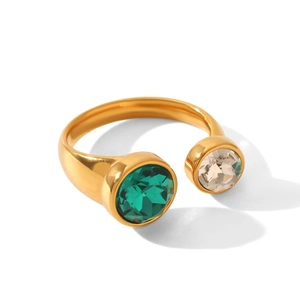 Détail d'une bague dorée ajustable avec zircons vert émeraude et couleur champagne