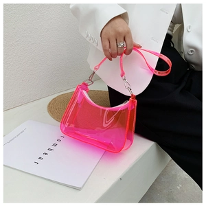 Close-up of neon pink transparent PVC baguette bag with silver chain and hardware