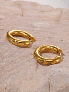 Detailed close-up of 18k gold-plated thick hoop earrings with star-engraved zircon stones