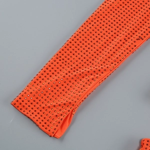 Gros plan détaillé de la robe orange avec strass brillants et tissu extensible ajouré