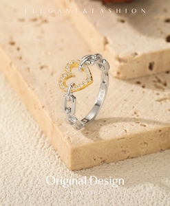 Macro shot of S925 sterling silver ring with a gold heart and chain link band