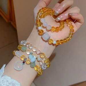 Detailed shot of beaded bracelet with white chalcedony, citrine, and jade animal charms