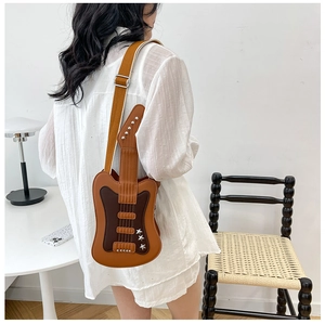 Detail of creative guitar-shaped crossbody bag with brown patchwork and star rivets