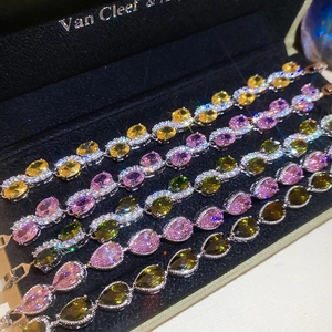 Macro shot of colorful pear and oval cut gemstones with pave diamond halos in jewelry box
