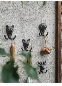Retro-Tierhaken aus Gusseisen mit Hund, Katze, Hirsch und Schwein auf einer grauen Steinwand