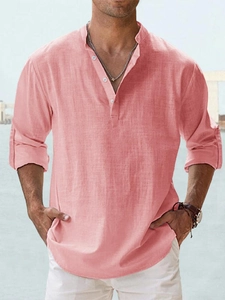 Detail of coral linen shirt featuring a buttoned Henley collar and breathable fabric