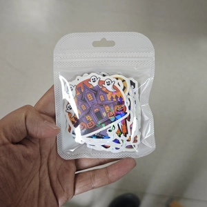 Detailed view of holographic Halloween stickers with ghost and pumpkin designs in a clear bag