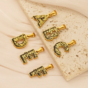 Detailansicht der goldfarbenen Edelstahl-Buchstabenanhänger A B D E F mit Emaille-Inlay