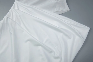 Gros plan détaillé de la texture fine du tissu blanc avec des plis doux et naturels