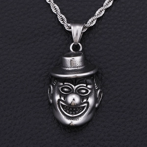 Macro shot of silver vintage-style clown pendant necklace on black textured leather