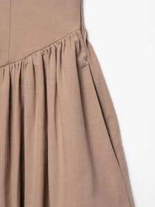 Detail of khaki linen dress fabric texture with pleats and invisible zipper closure