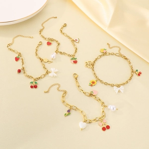 Détail de la chevillère dorée aux breloques de fruits, cerises rouges et fraises