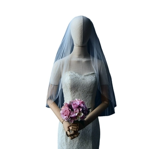 Blue-grey long tulle wedding veil with elegant trail shown on mannequin with floral bouquet