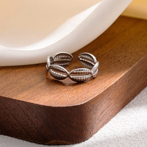 Close-up of silver multilayer ring with textured oval units on a wooden display stand