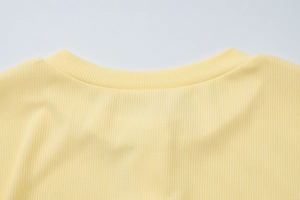 Gros plan sur la maille côtelée jaune vif et l'encolure d'un cardigan d'hiver