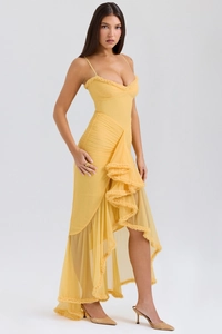 Detailed view of yellow long dress with ruffles, pleats and irregular layered skirt