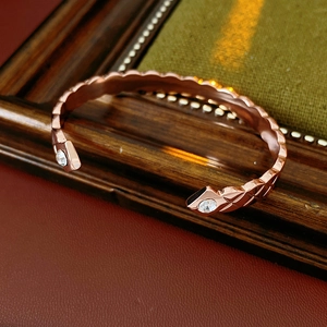 Vue détaillée du bracelet jonc or rose avec texture écaillée et accents de zircon