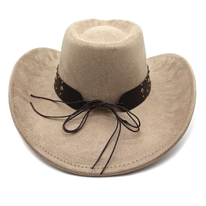 Dettaglio cappello da cowboy in camoscio kaki con cinturino in pelle e borchie in bronzo