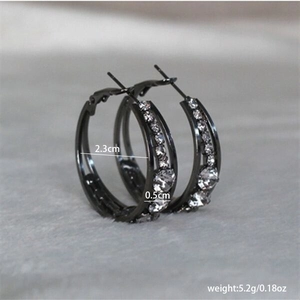 Detail showing dimensions of black hoop earrings with crystal inlay on plush background