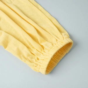 Detail view of the yellow long cardigan set showing elasticated cuffs and knit texture