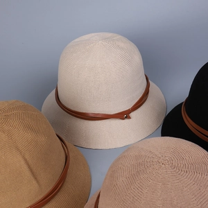 Detail of knitted bucket hats showing leather buckle accent and textured weave patterns