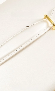 Close-up of white waterproof leather jewelry box with gold buckle and double stitching