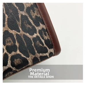 Close-up of leopard print fabric texture with premium brown leather piping detail