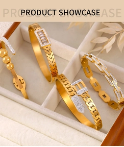 Detail view of four gold-plated chain style bracelets with zircon inlays in a jewelry box