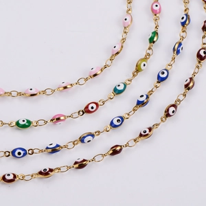 Macro detail of Turkish evil eye jewelry chains with colorful enamel inlay in gold finish