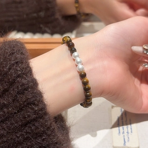 Close-up of vintage tiger eye beads and pearls on an elastic beaded bracelet