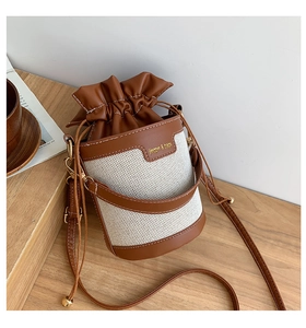 Detail of drawstring closure and contrast stitching on canvas bucket bag