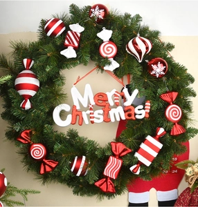Detail of a Christmas wreath with red and white candy ornaments and Merry Christmas sign