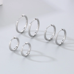Close-up of three pairs of silver stainless steel hoop earrings in various sizes