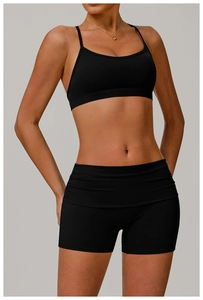 Close-up of black sports bra and high-waisted yoga shorts with stylish folded waistband