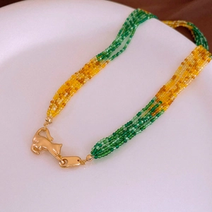 Macro detail of multilayered crystal beads with a golden cat-shaped metal clasp