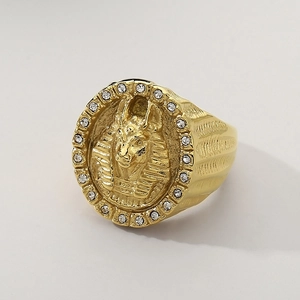 Macro detail of gold Anubis ring featuring intricate carvings and white crystal inlay