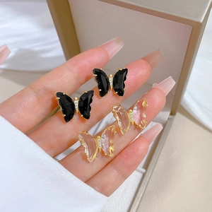 Close-up of butterfly earrings in black and crystal finish with inlaid crystal details