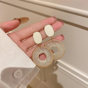 Detailed view of french vintage pearl earrings with gold wire woven rings held by hand