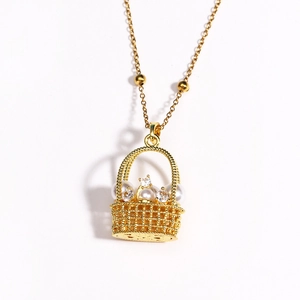 Gros plan du pendentif panier fleuri doré avec perles et zircons sur une fine chaîne