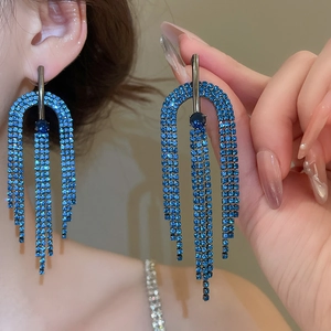 Détail de boucles d'oreilles en argent avec longs pompons de strass bleu électrique et cadre en U