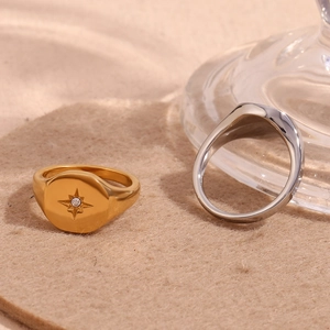 18K gold plated stainless steel North Star signet ring and silver band on felt pad