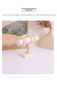 Pink silk T-bar jewelry stand displaying four jade bangles in a modern home setting