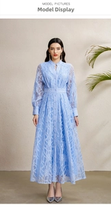 Détail d'une robe longue en dentelle bleu clair avec broderie florale et décolleté en V