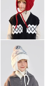 Close-up of children's warm knitted earflap hats with pom-poms and winter knitwear