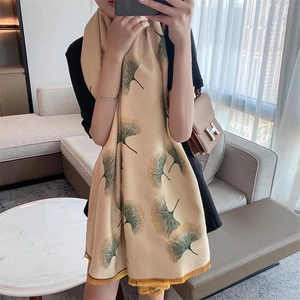 Detail of double-sided ginkgo leaf cashmere scarf with soft yellow fringe trim