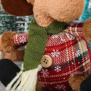 Gros plan détaillé d'un renne en peluche avec motif écossais rouge et flocons de neige