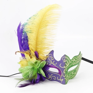 Colorful masquerade mask with purple green yellow feathers and gold glitter for carnival