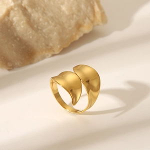 Detailed view of polished golden irregular heart shaped open ring on a stone base